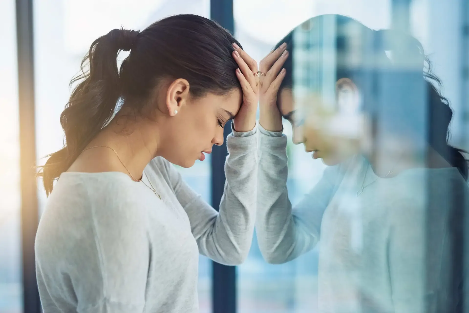 A woman looking stressed and overwhelmed at her desk